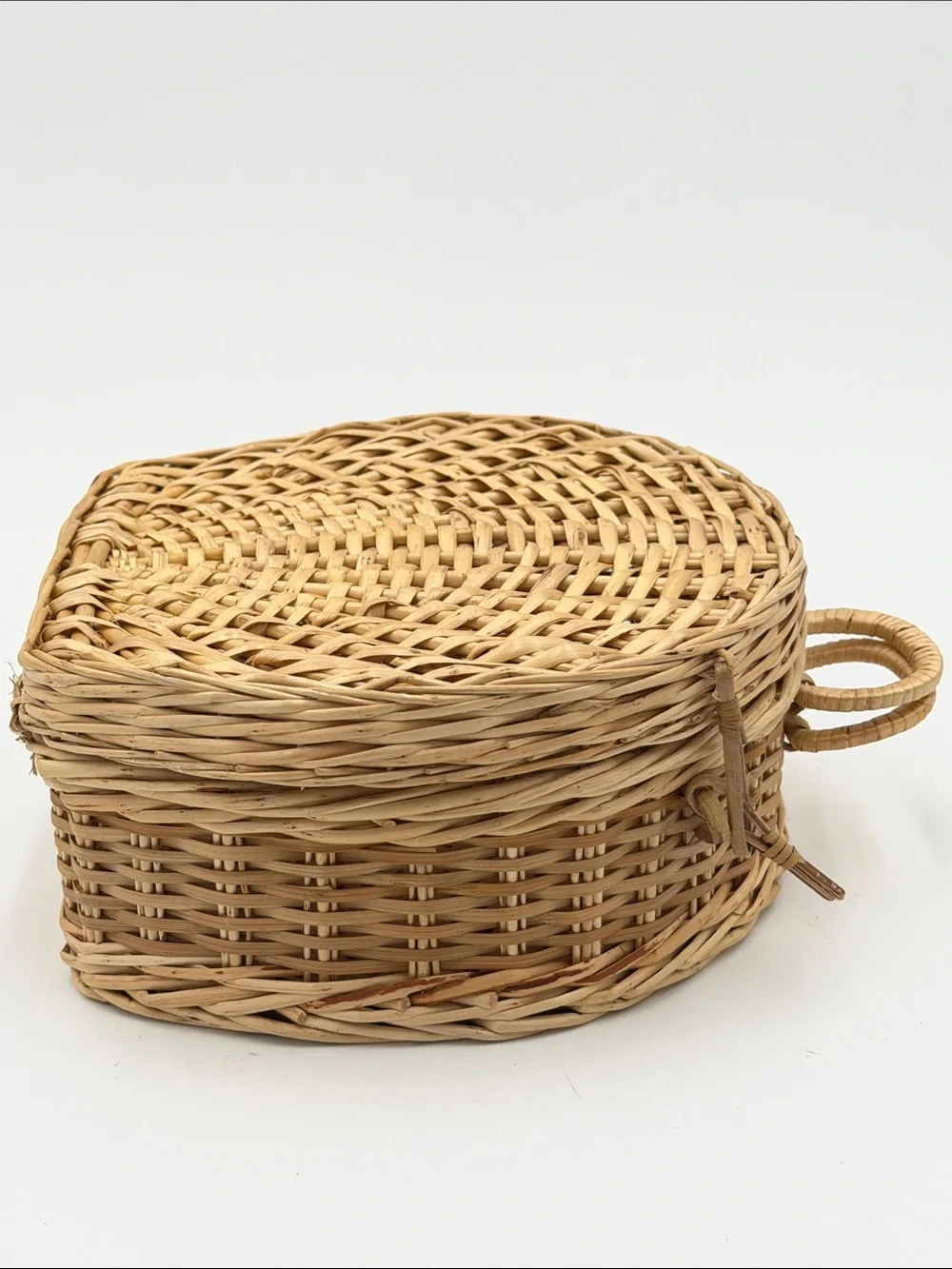 A Cute, charming vintage shell-shaped rattan storage basket with a front handle.